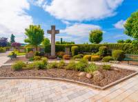 Eingangsbereich des Friedhofs mit zentralem 
Friedhofskreuz und Priestergräbern
